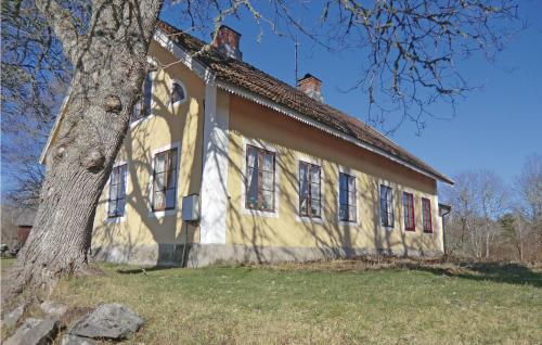 an old house with a tree in front of it at Beautiful Home In Högsby With Kitchen in Fågelfors
