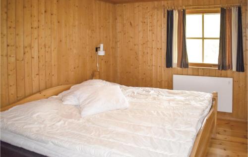Cama blanca en habitación de madera con ventana en Cozy Home In Lofsdalen With House A Mountain View, en Lofsdalen