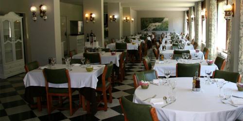 una fila de mesas en un restaurante con mesas y sillas blancas en El Pradet, en El Serrat