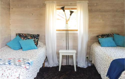 1 dormitorio con 2 camas, mesa y ventana en Amazing Home In Lttorp With Kitchen, en Böda