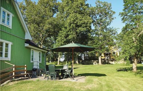 a green house with a table and an umbrella at Holiday Home Kallinge With A Fireplace 07 in Möljeryd