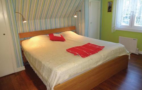 a bed with two red pillows on it in a room at Awesome Home In Kallinge With 2 Bedrooms in Möljeryd