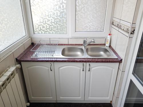 a kitchen with a sink and two windows at Apartament Melinda in Oradea