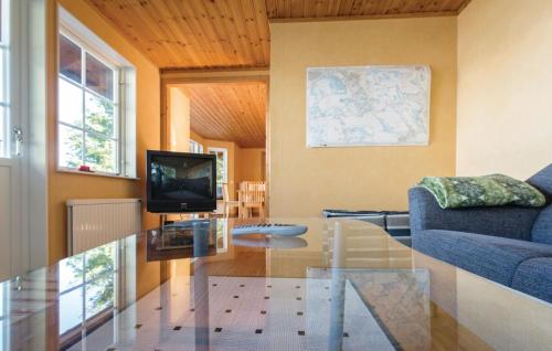 a living room with a glass table and a tv at Lovely Home In Kvicksund With Sauna in Kvicksund