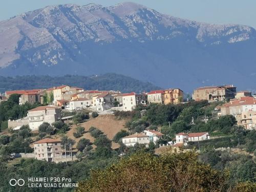 un pueblo en una colina con montañas en el fondo en Casa Vacanze - B&B Il Tempone, en Prignano Cilento
