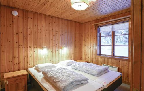 a bedroom with a bed in a wooden wall at Amazing Home In Sysslebck With Kitchen in Sysslebäck