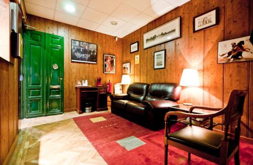 Una sala de estar con un sofá y una puerta verde. en Hostal Asunción, en Madrid