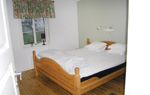 1 dormitorio con 1 cama con sábanas blancas y ventana en Cozy Home In Hestra With Kitchen, en Valdshult