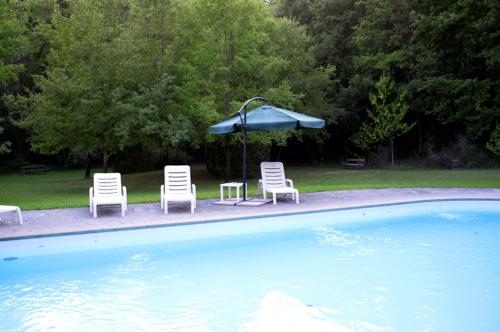 a group of chairs and an umbrella next to a pool at San Giorgio Villam in Orvieto