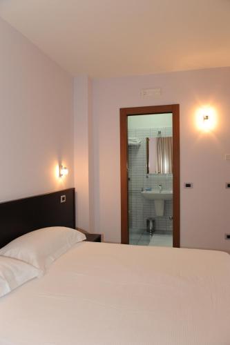 a bedroom with a bed and a bathroom with a sink at Country House Il Papavero in Bagnoli Irpino