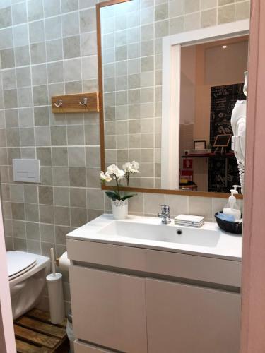 een badkamer met een wastafel, een spiegel en een toilet bij Flor Liz in Lissabon