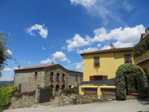 a yellow building next to a stone building at Borgo Sicelle Residence in San Donato in Poggio