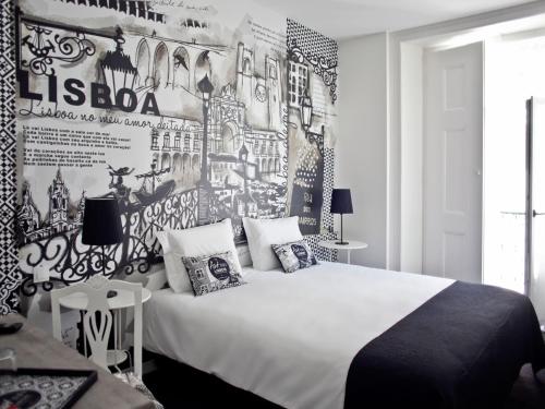 a bedroom with a white bed and a wall with posters at The ART INN Lisbon in Lisbon