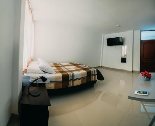 um pequeno quarto com uma cama num quarto em Keylas Hotel em Ica