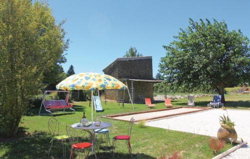 - un jardin avec une table, des chaises et un parasol dans l'établissement Cozy Home In Pernes Les Fontaines, à Pernes-les-Fontaines