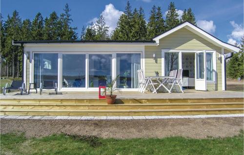 a house with a deck with a table and chairs at Lovely Home In Bolmsö With Kitchen in Bolmsö
