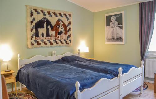 a bedroom with a white bed with a blue blanket at Nice Home In Färentunna in Ölsta