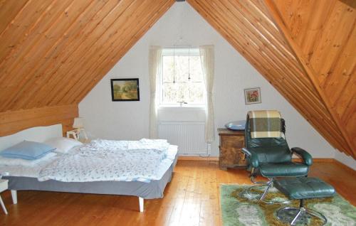 a bedroom with a bed and a chair in a attic at Holiday Home Barkhult Ullared in Källsjö