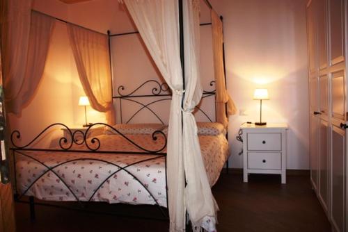 a bedroom with a bed with a canopy and a table at La Codarda country house in Pescosolido