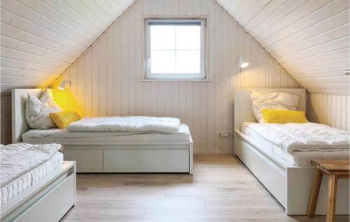 a attic room with two beds and a window at Awesome Home In Zerpenschleuse With Kitchen in Zerpenschleuse