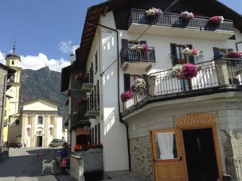 a white building with flower boxes on the balconies at Hotel Roseg in Chiesa in Valmalenco