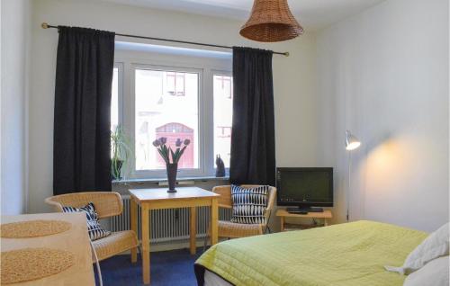 a bedroom with a bed and a window with a table and chairs at Awesome Apartment In Ystad With Kitchen in Ystad