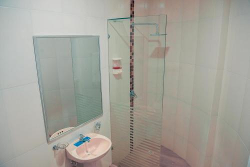 a bathroom with a sink and a glass shower at Hotel Casa Arnaldo "Esmeraldas" in Esmeraldas