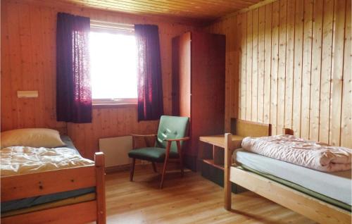 a bedroom with a bed and a chair and a window at Storhytta in Vinstra
