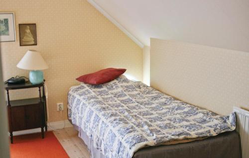 a bedroom with a bed with a red pillow on it at Awesome Home In Eskilstuna With 2 Bedrooms And Wifi in Sundby