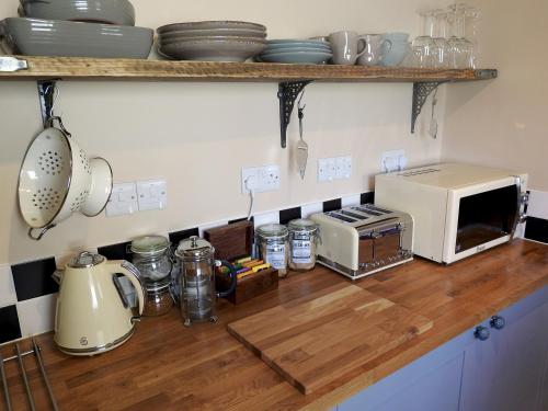 a kitchen with a counter with a microwave and appliances at Heatopia Apartment in Newcastle upon Tyne