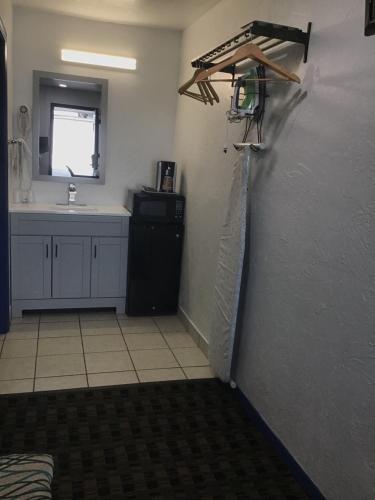 a room with a kitchen with a sink and a wall at Budget Inn & Suites in Oklahoma City