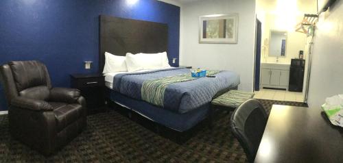 a hotel room with a bed and a chair at Budget Inn & Suites in Oklahoma City