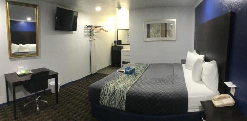 a hotel room with a bed and a desk at Budget Inn & Suites in Oklahoma City
