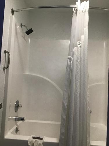 a bathroom with a shower with a shower curtain at Budget Inn & Suites in Oklahoma City