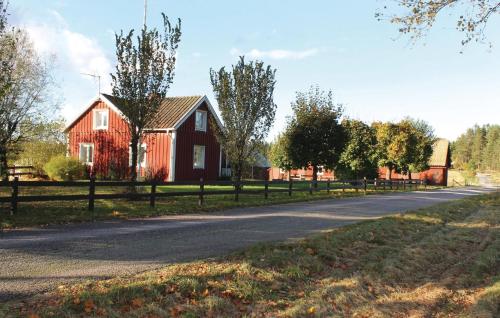 a red house on the side of a road at Two-Bedroom Holiday Home Skeppshult 02 in Skeppshult