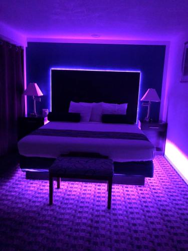 a bedroom with a large bed with purple lighting at Budget Inn & Suites in Oklahoma City