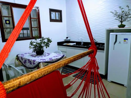 a kitchen with a table and a red net at Casa Wilson in Penha