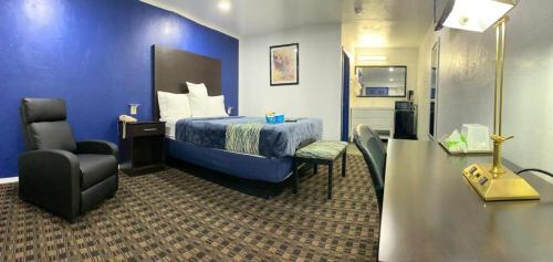 a hotel room with a bed and a chair at Budget Inn & Suites in Oklahoma City