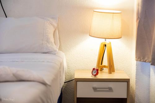 a bedroom with a bed and a lamp on a night stand at San Pedro Suite in San Pedro La Laguna