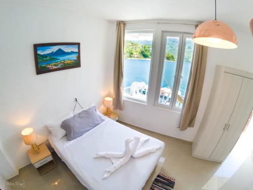 a room with a bed and a large window at San Pedro Suite in San Pedro La Laguna