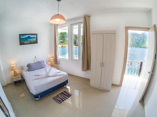 a bedroom with a bed and a large window at San Pedro Suite in San Pedro La Laguna