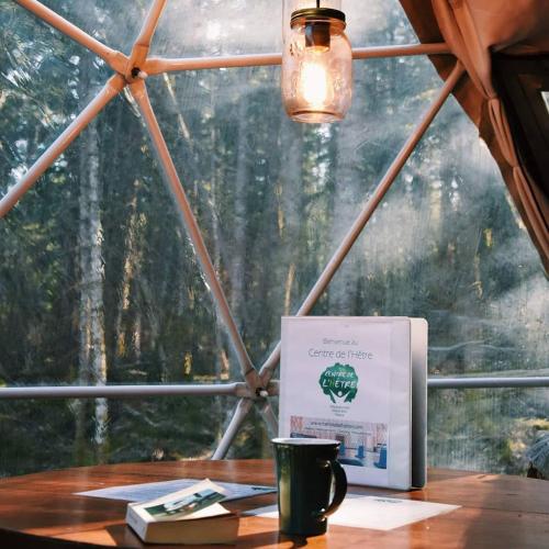 a table with a sign on it in front of a window at Centre de l'Hêtre in Lac-Beauport