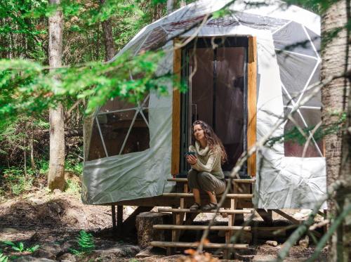 a woman sitting on a stairs in a tent at Centre de l'Hêtre in Lac-Beauport