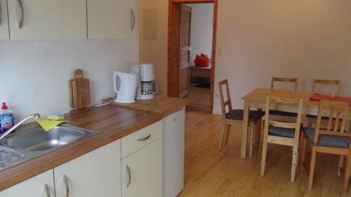 a kitchen with a sink and a table with chairs at Apartmentpension am Stadtschloss in Potsdam
