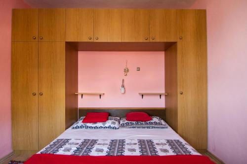 a bedroom with a bed with red pillows on it at Apartment Marko - 10 m from sea in Stomorska