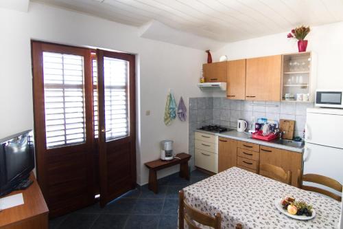 a small kitchen with a table and a refrigerator at Apartment Marko - 10 m from sea in Stomorska