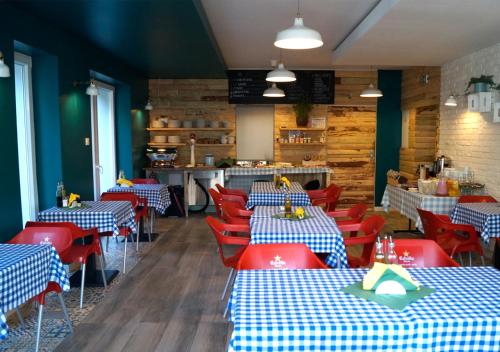 un ristorante con tavoli e sedie blu e rossi di Willa Nest a Unieście