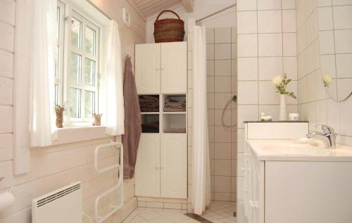 un bagno bianco con lavandino e finestra di 4 Bedroom Nice Home In Osby a Osby