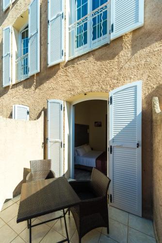 a patio with a table and chairs and a bedroom at Hotel Le 21 in Saint-Raphaël