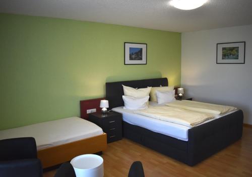 two beds in a room with green walls at TIPTOP Hotel am Hochrhein in Bad Säckingen